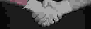Two hands shaking each other wearing white gloves