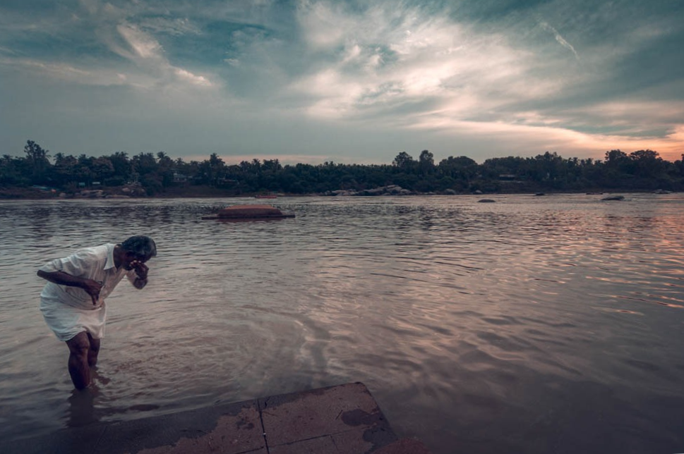 A man offering prayers in the Tungabhadra river Hampi.