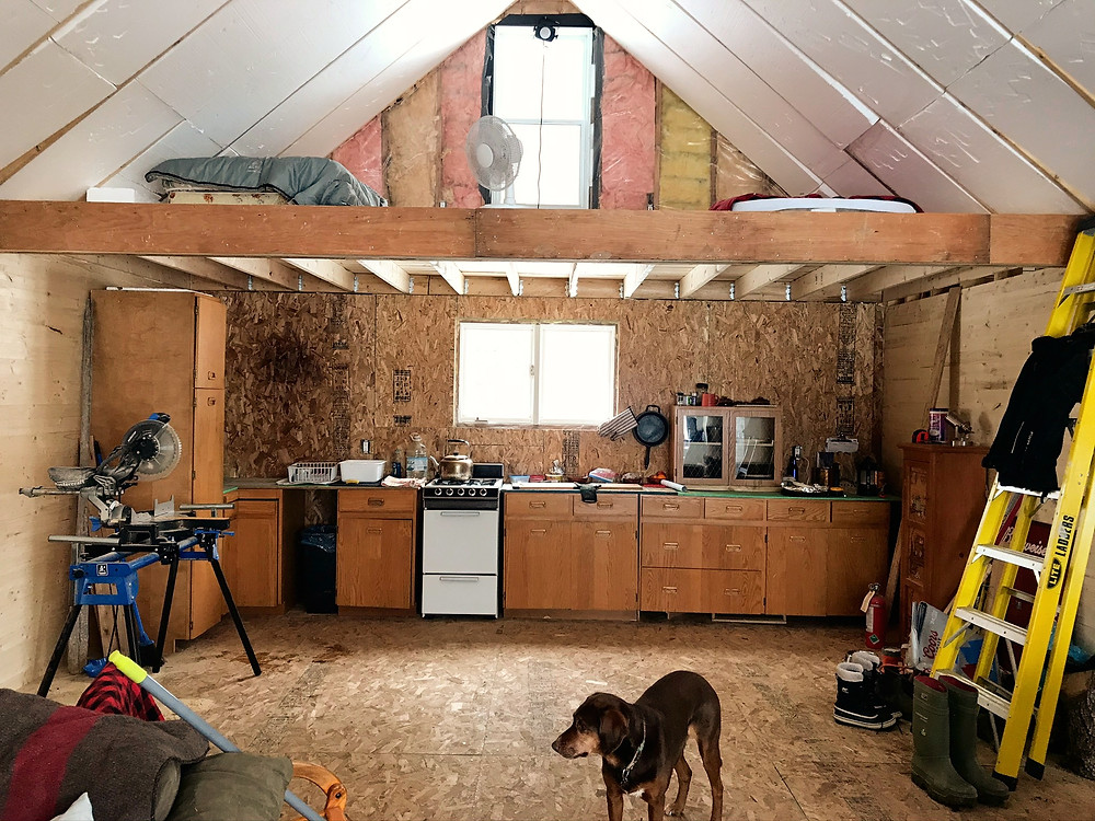 An unfinished kitchen under a loft in a diy cabin