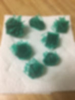 Dice on a paper towel. They have been removed from the base, but still have supports on the braille and edges.