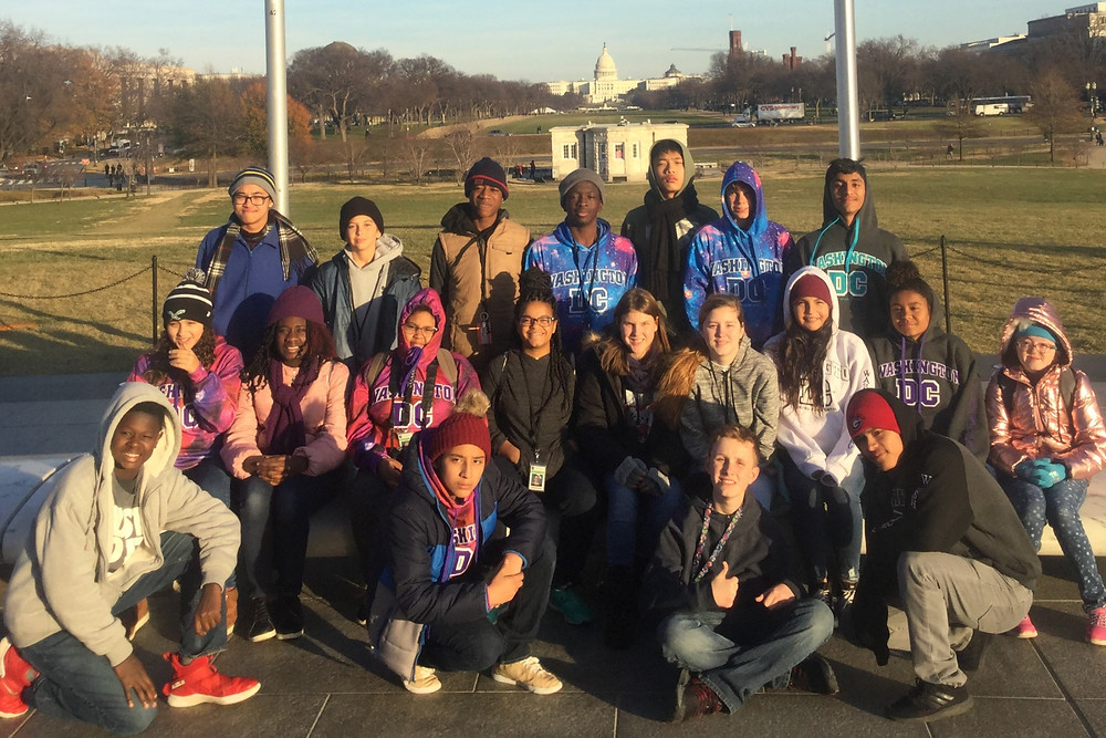 Deaf Middle School 8th graders posing for photo with the U.S. Capitol building in the background.