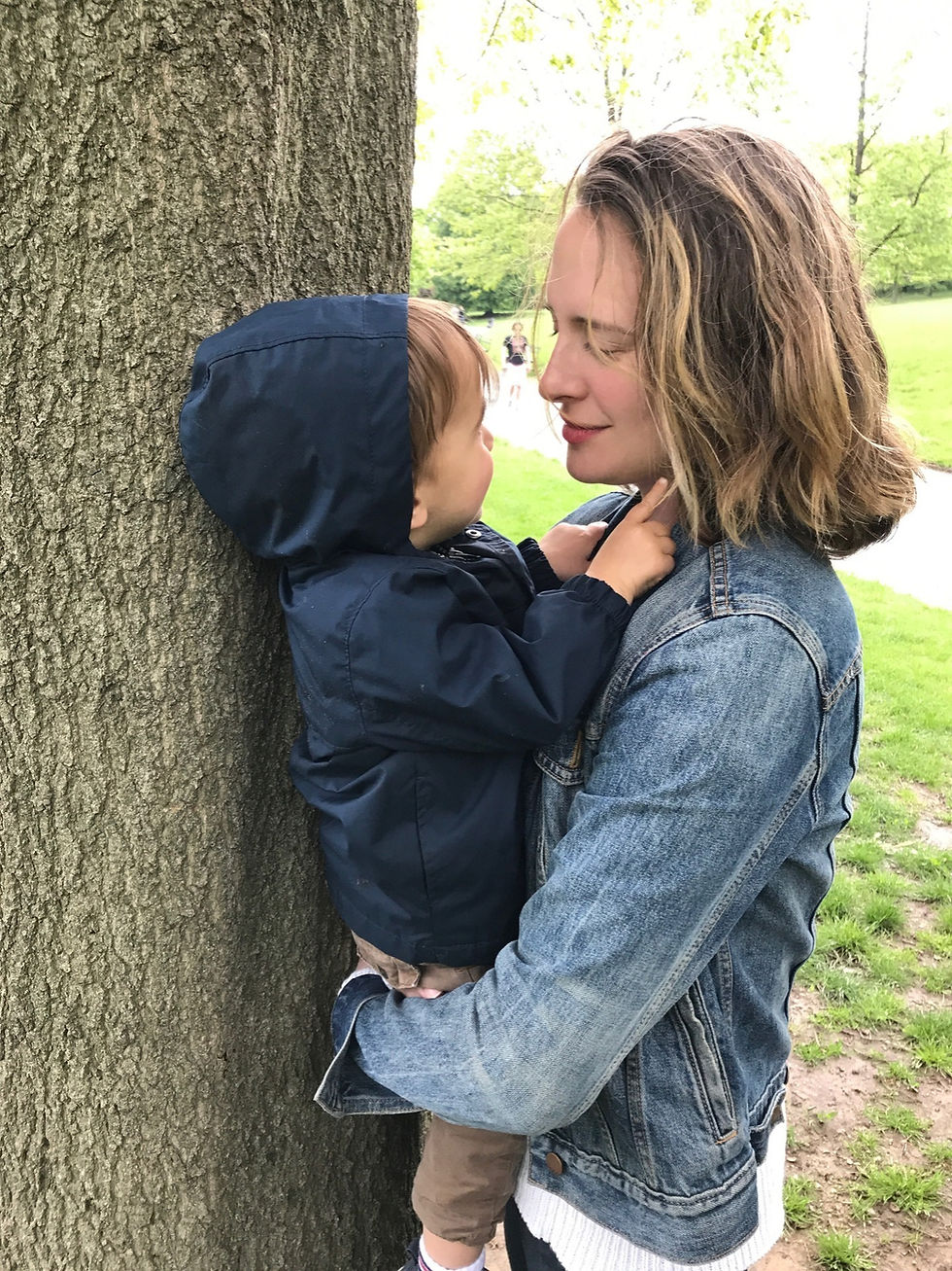 A small child and his mother, the author outside near a tree.