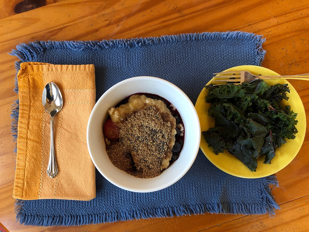 Whole foods, plant-based breakfast of steel cut oats, banana, blueberries, cinnamon, flax seeds, chia seeds, and green matcha powder.