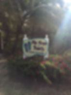 resort sign for "Flip Flops on the Beach" in front of a palm tree