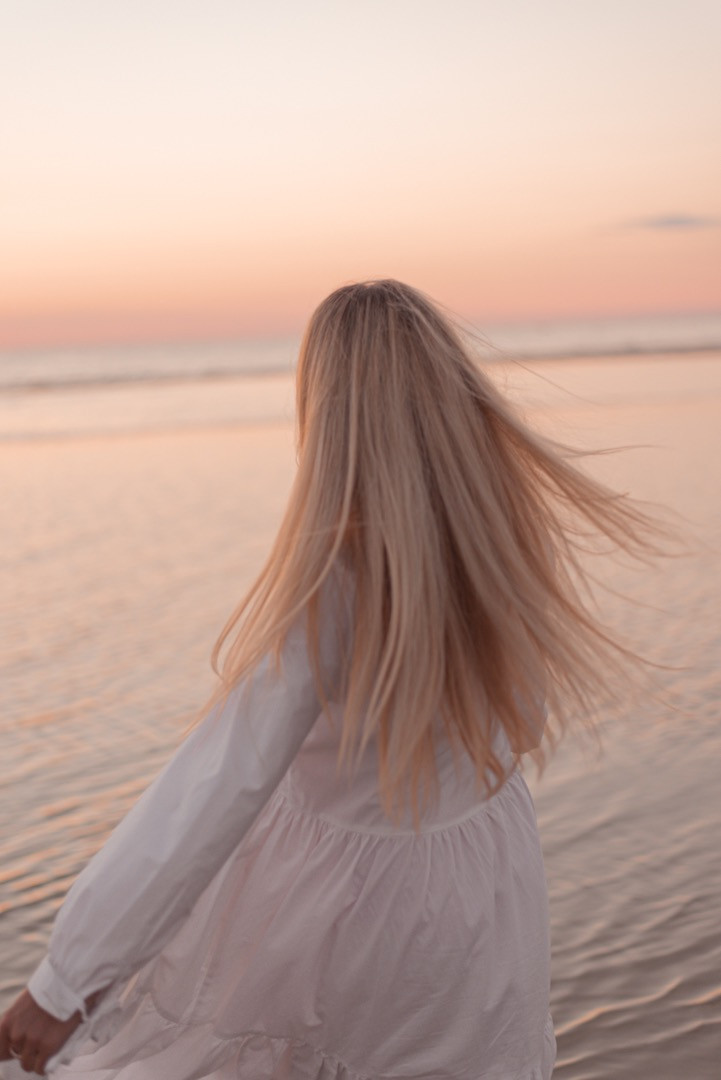 Photo session with a girl in a white dress at the beach with the sunset in Tallinn