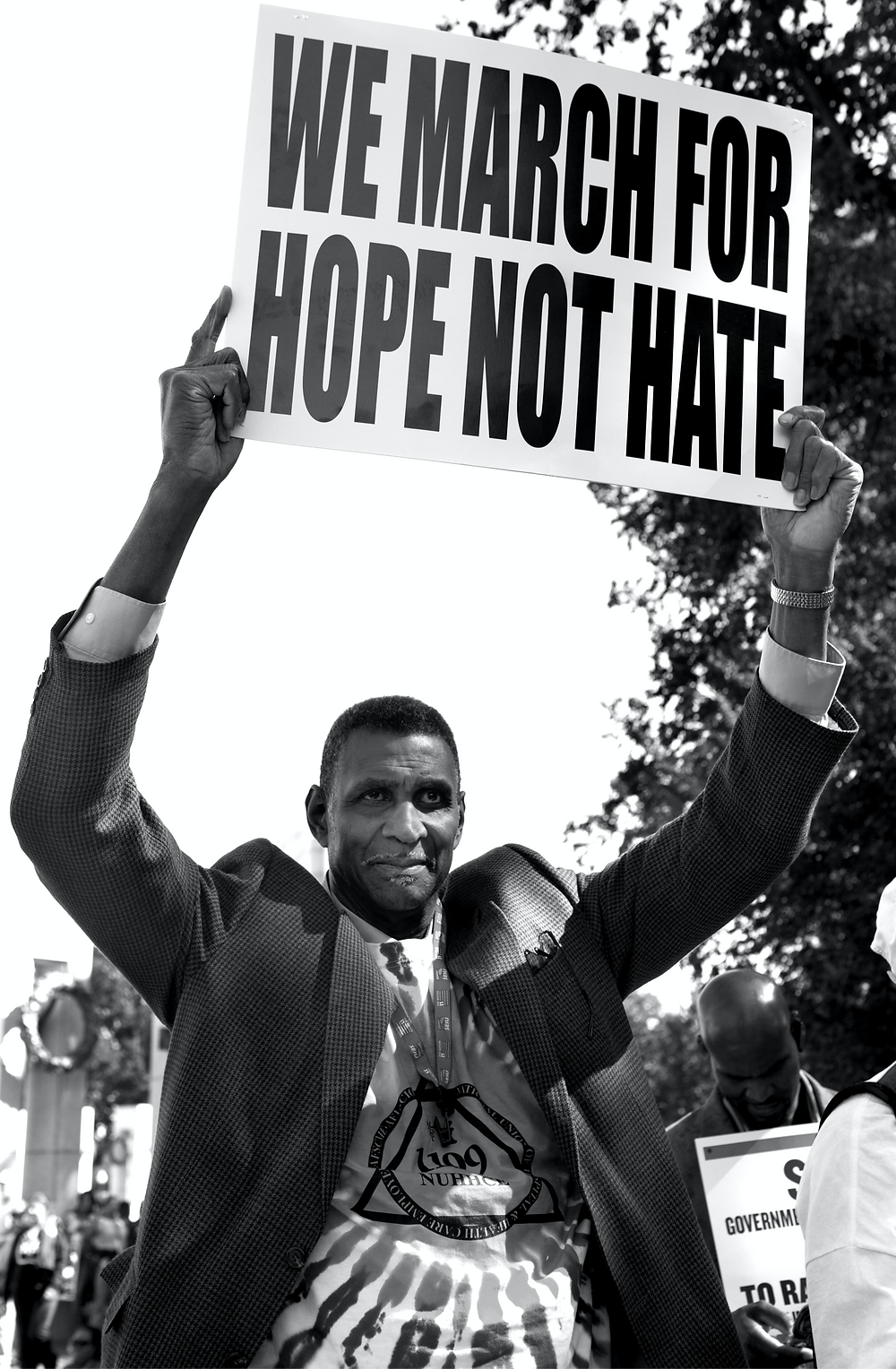 Black man holds up a sign that says, We march for hope not hate