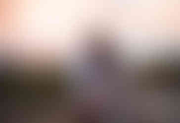 Couple cuddling gazing out to the water during sunset