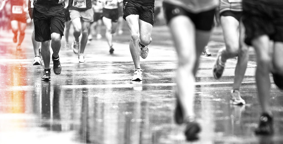 Ground view of marathon runners legs on wet road