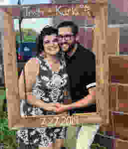 A woman and man pose in a photobooth at a outdoor Wisconsin wedding ceremony