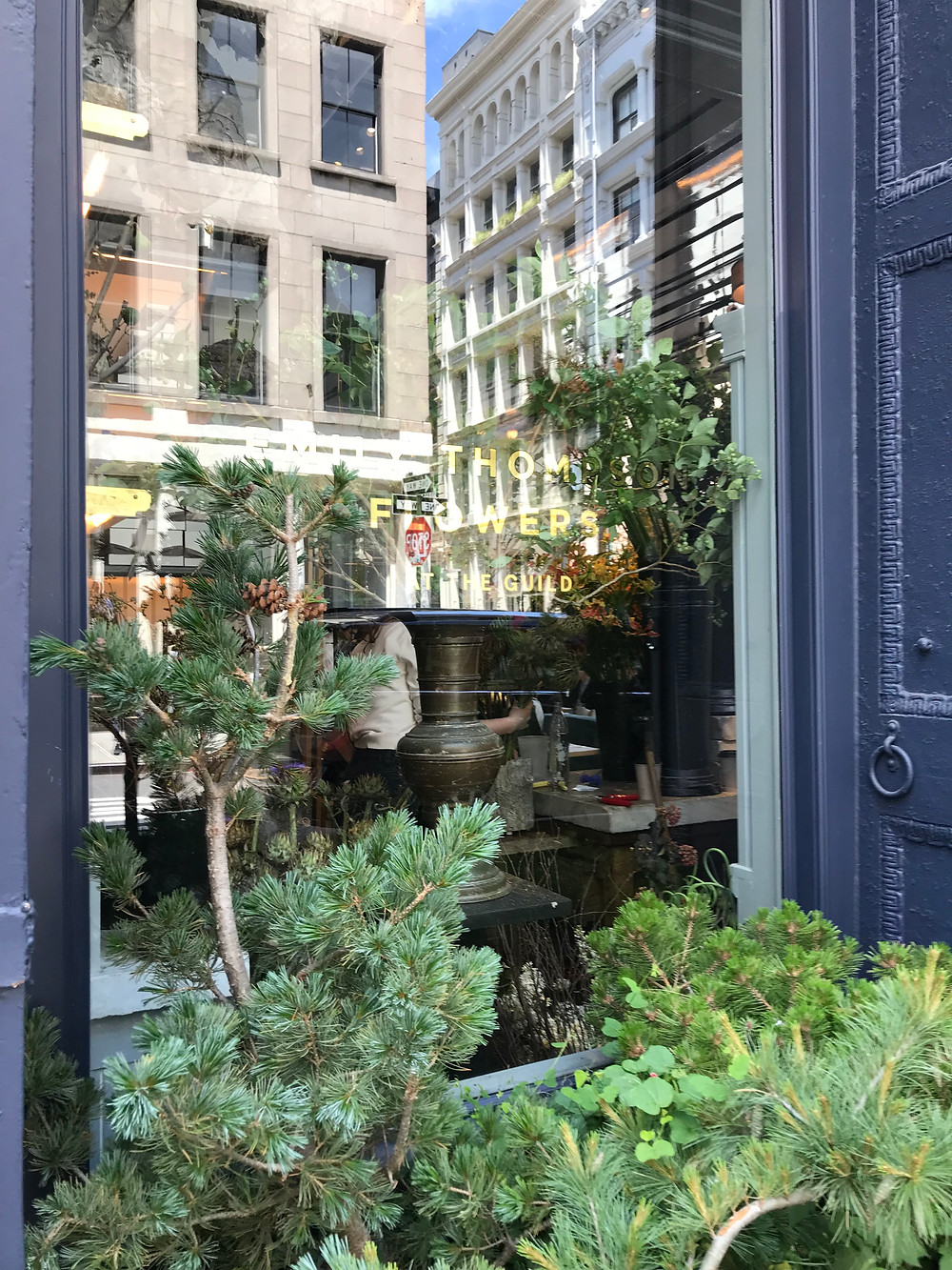 buildings of New York reflect in window of RW Guild