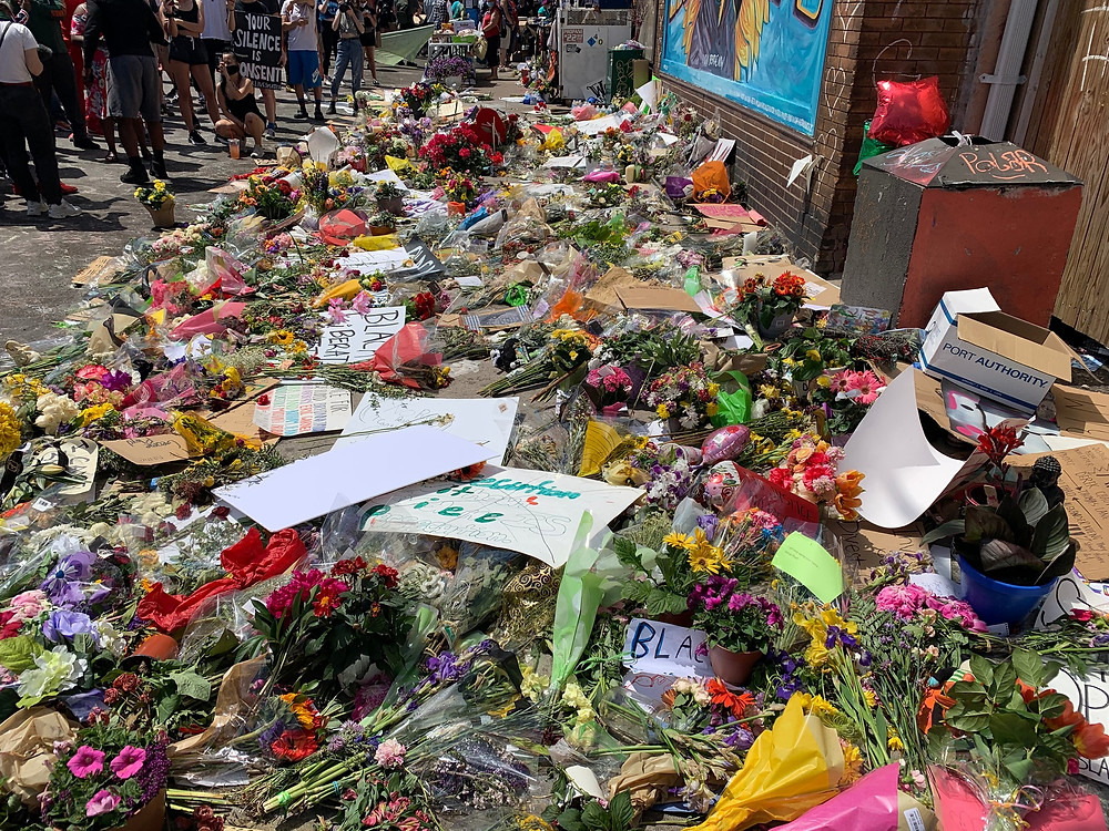 Image: Flowers at the George Floyd Memorial. Photo Credit: Cirien Saadeh
