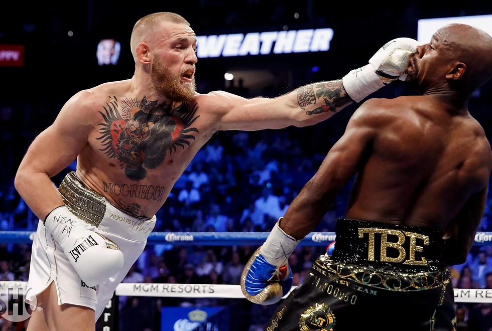 In August 2017, the entire sporting world was transfixed on the cross-promotional fight between the two biggest stars in combat sports.  In a surreal moment, undefeated boxing champion Floyd Mayweather came out of retirement to welcome UFC champion Conor McGregor into his world inside the T-Mobile Arena in Las Vegas. It was truly a spectacle few could have imagined as they witnessed the greatest boxer of his generation square off against a brash mouthed Irishman with zero professional boxing fights.  So how did this fight even come about? Why would a a 40-year-old boxer, who hadn’t fought in two years, want to fight 30-year-old mixed martial arts champion in the prime of his career?  According McGregor’s head coach John Kavanagh, the process behind making the “money fight” wasn’t as challenging as it was made out.  “It was funny how it all came about,” said Kavanagh during an appearance on the Joe Rogan Experience. “Shortly after [McGregor’s win over Eddie Alvarez at UFC 205] we were at a function and I pulled Conor aside and shook his hand and said ‘Alright, you’re done. Enjoy the rest of your life.’ He was shocked I was saying this. But I said ‘What else are you going to do? You’re a two-weight champion, you’ve gone out the other end of this meat grinder with no damage. You’re in a very small percentage and you’ve made plenty of money. Go off and enjoy yourself.’  “Then a couple of months went past and the Mayweather fight started talking. I could understand because now his grandkids would be financially secure. So it made sense because it was a big payday. It didn’t make sense for any other reason. He enjoyed the competition side of it. No matter what you’re doing with Conor, it’s going to be a competition.  “So when him and Floyd started having a back-and-forth and goes ‘let’s go to boxing and be the best boxer in the world.’ For me, on the outside, it made sense to do. Nothing else was really make sense at the time. It was going to be damaging. Boxing is a horrendous sport to prepare for. We’re going to be looking at one thing, punches to the head. But it’s so damaging. The only justification I could see is his grandkids would be financially set.”
