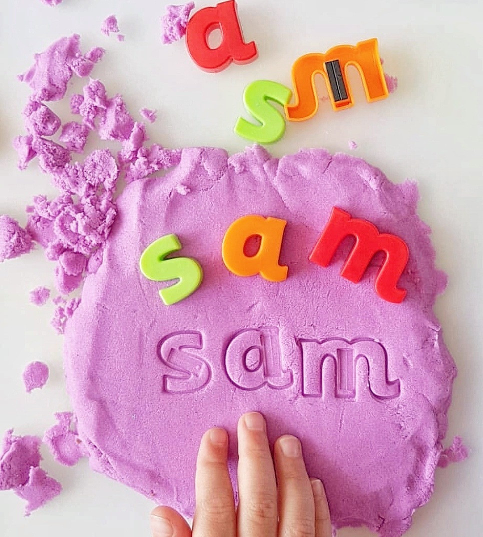 child learning names with kinetic sand