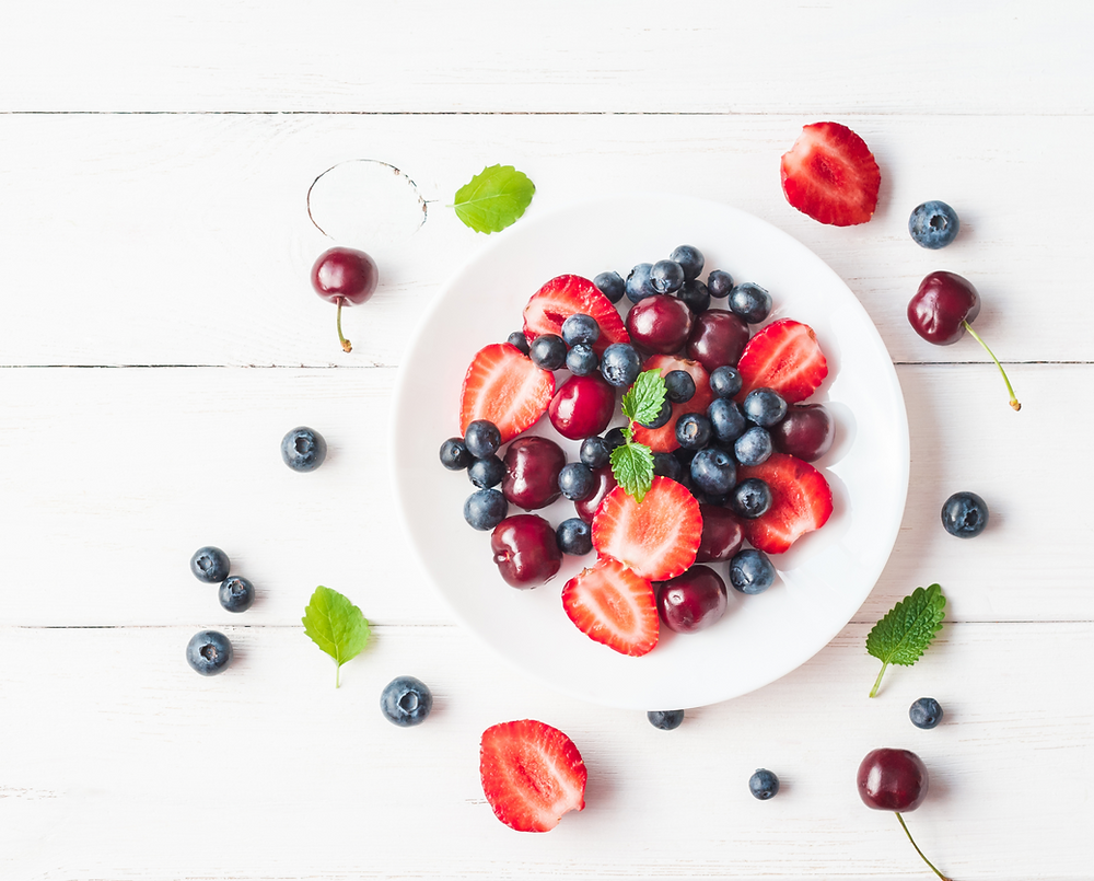 healthy organic strawberry cherry blueberry flat lay on white background