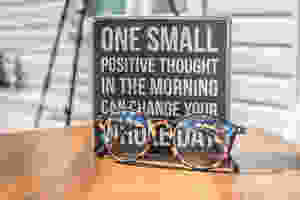 sign displaying motivational thought next to glasses