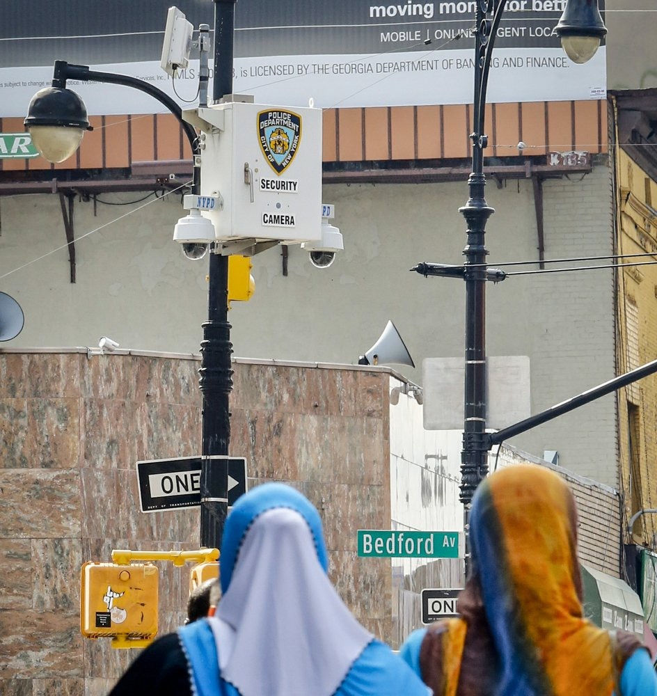 Two women walking towards facial recognition camera in New York City. 