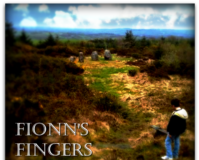 A row of 5 standing stones graduating in size, set in an elevated clearing overlooking rolling countryside.