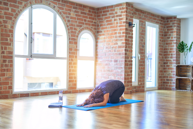 Woman in yoga studio doing child's pose