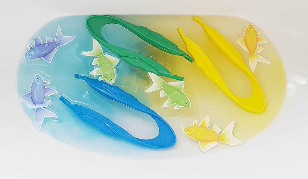 colour mixing blue and yellow water in a sink with toy fish