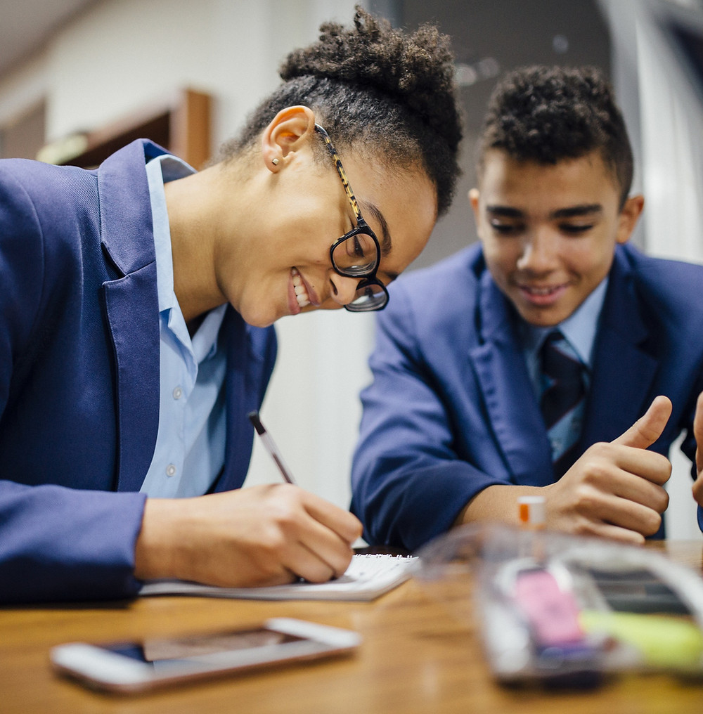 Two students in classroom studying for a maths A level exam