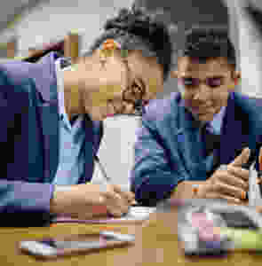 Two students in classroom studying for a maths A level exam