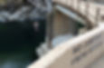 Despite a sign saying "No Jumping from Bridge," a boy is jumping from the bridge.