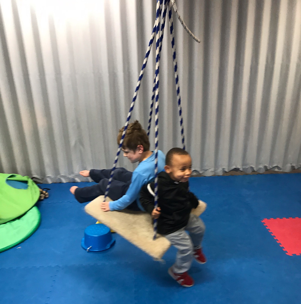 preschool students swing together in gross motor room
