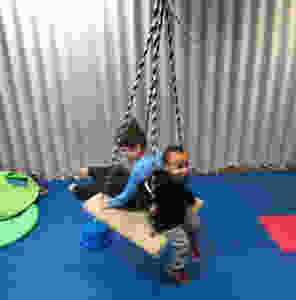 preschool students swing together in gross motor room