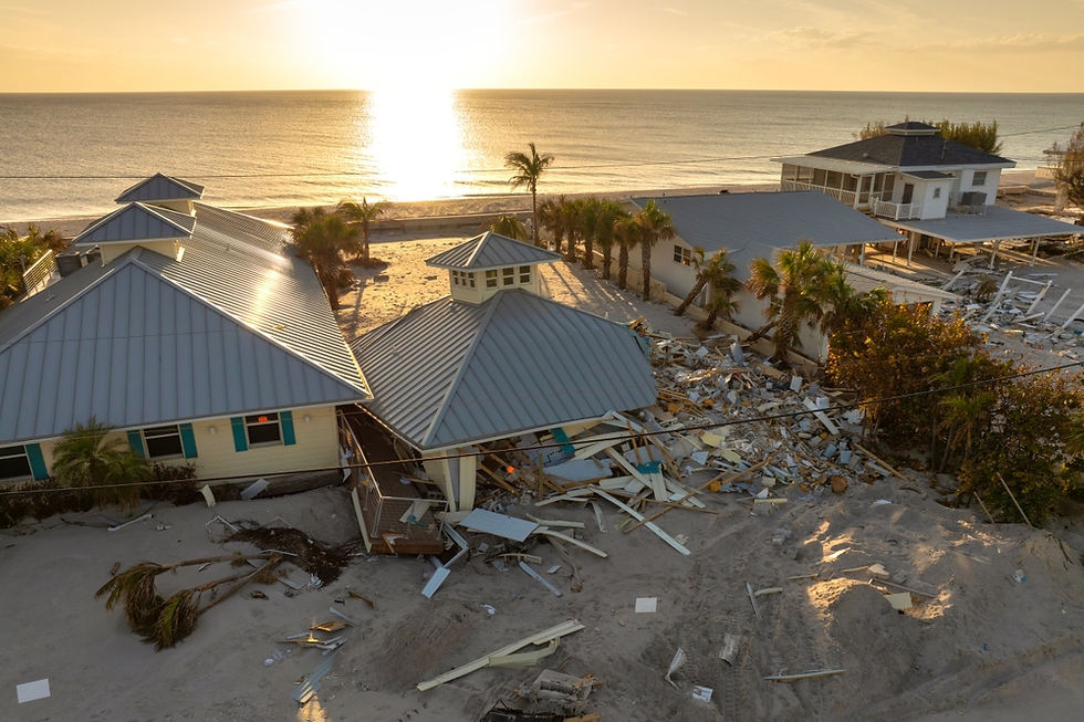 A storm-damaged home with partial missing roof, visible wind damage, broken gutters, and water intrusion following a hurricane. An insurance appraiser and roofing contractor inspect the property while reviewing documents and damage estimates, representing a homeowner seeking a fair insurance appraisal for hurricane damage after receiving a low settlement offer.