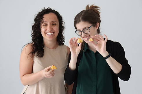 two students smiling and holding their polymer clay art