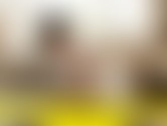 "A mother smiles while breastfeeding and cradling her newborn baby in a cozy postpartum room"