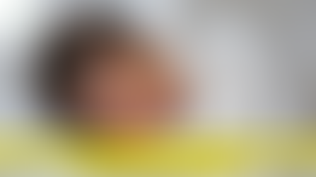 "Newborn baby with natural dark hair sleeping on a cozy white bed"