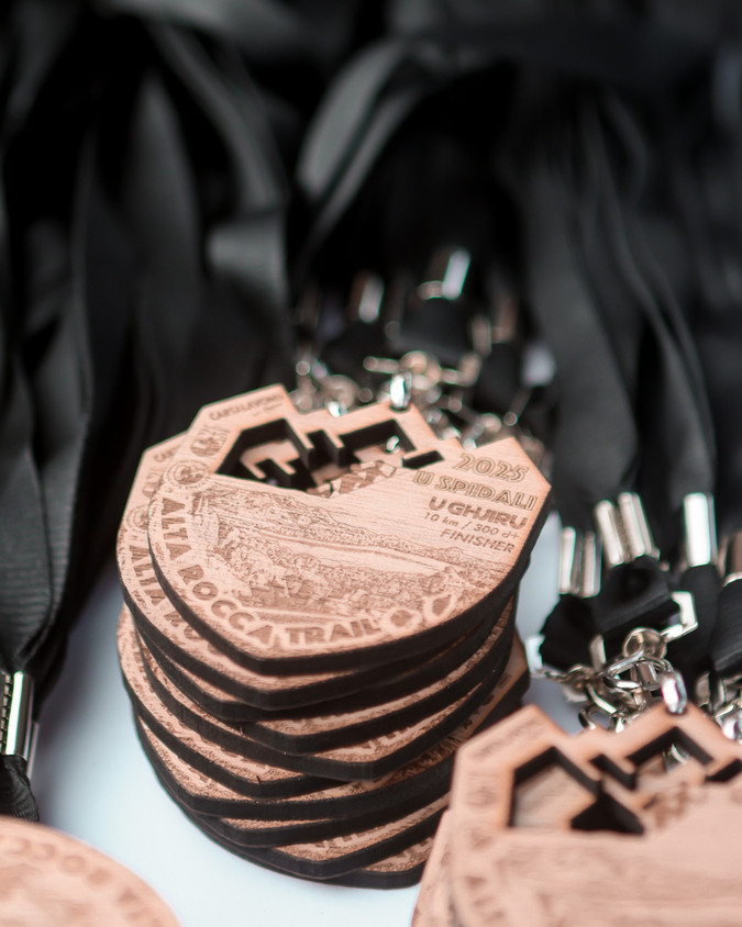Médailles en bois 2019 ROCCA TRAIL CHALLENGE empilées, avec rubans noirs.
