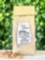 Sweet South Market Pecan Coffee bag against a blurred green background, Sweet South.