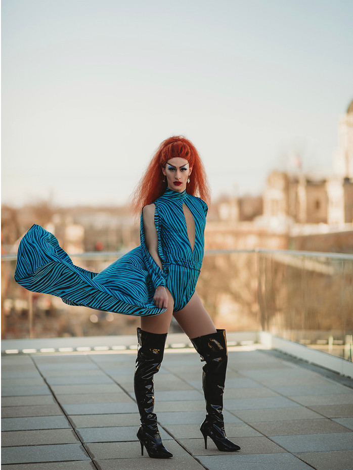 Drag queen, red orange hair, black boots and blue outfit