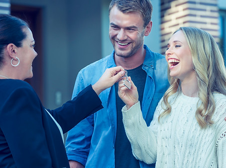Man and woman getting handed keys to a new home on the real estate law page