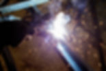 A man is welding metal with a torch The sparks and smoke from the welding process create a
