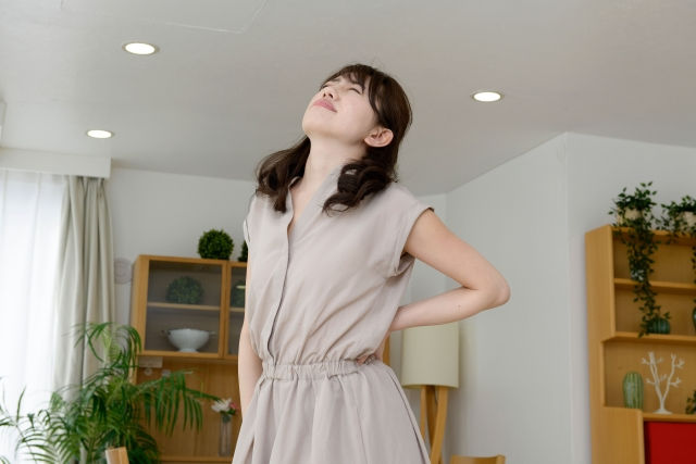 腰をおさえる女性