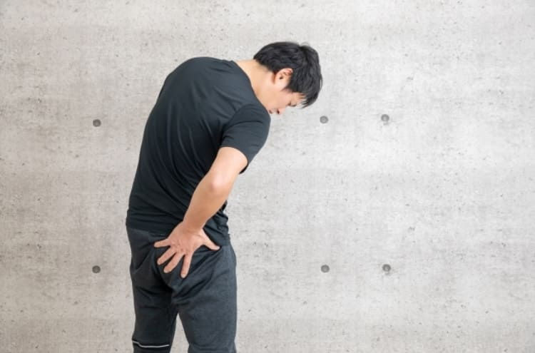 腰に痛みを感じる男性