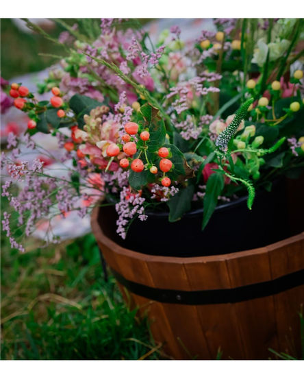 a wooden barrel filled with flowers and berries