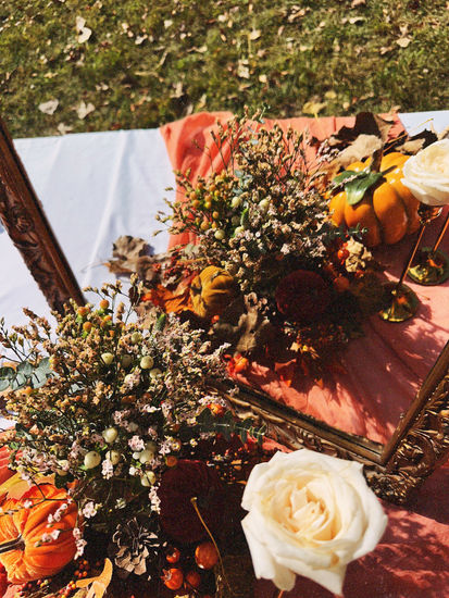 a table with flowers and pumpkins on it