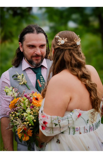 a bride and groom looking at each other with the bride holding a bouquet of flowers