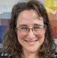 Lady with brown hair and glasses smiling.