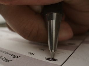 Hand filling out a ballot