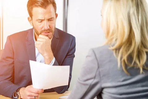 Eye-level view of a stack of resumes on a wooden table