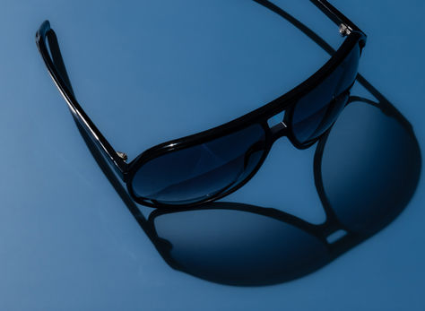 Dior sunglasses product photography in an in-home studio in Toronto, Canada with harsh shadow cast using studio light.