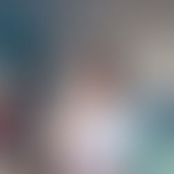 Girl smiling and looking at smartphone in front of laptop computer.