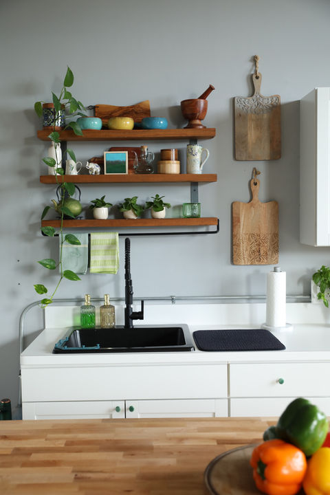 Kitchen sink, cutting boards, and bowls and plants on a shelf in The Little Studio at October Two.