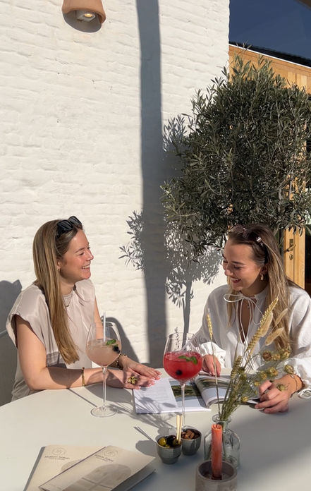 Twee meisjes die aan het aperitieven zijn in de zon.