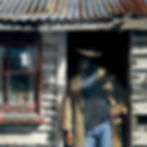 worn facade of a shed with figure partly emerging